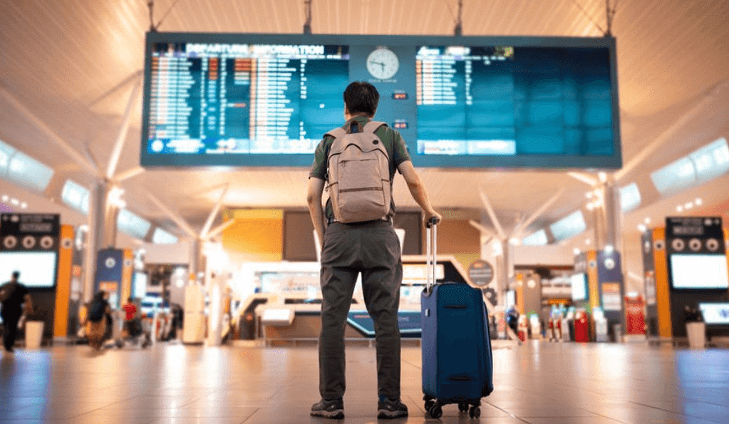 Last minute holiday travel booking at airport with luggage and tickets - ready for spontaneous vacation